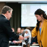 A student receives her ring from Dr. Pung